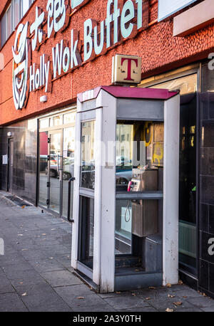 Vecchia cabina telefonica, la Telekom, fuori servizio, distrutto su Gladbecker Street a Essen, nella parte anteriore di un Asia Ristorante a Buffet, Foto Stock