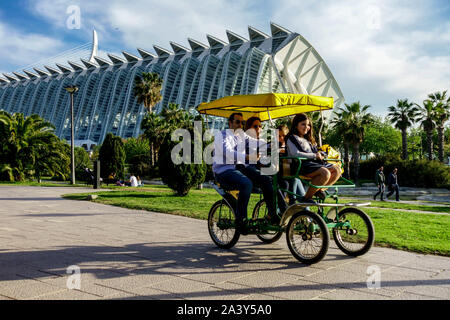 Valencia Spagna gente in bicicletta in famiglia Turia Park a Qudracycle, Valencia Città delle Arti e delle Scienze, parco cittadino con architettura moderna Foto Stock