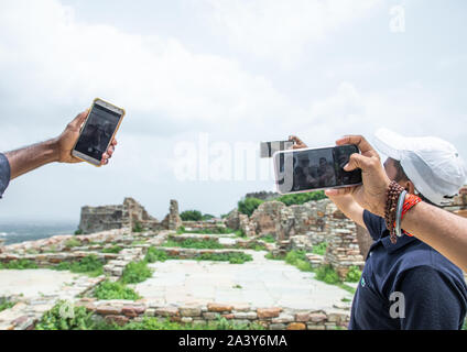 I turisti tenendo selfies davanti alla rovina rana kumbha palace all'interno di Chittorgarh Fort complesso, Rajasthan, Chittorgarh, India Foto Stock