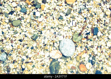 Macro close up di riso grezzo dimensioni multi-colore lucido bagnato granelli di sabbia e ghiaia texture, vista dall'alto. Kleopatra beach, Alanya, Antalya, Turchia. Foto Stock