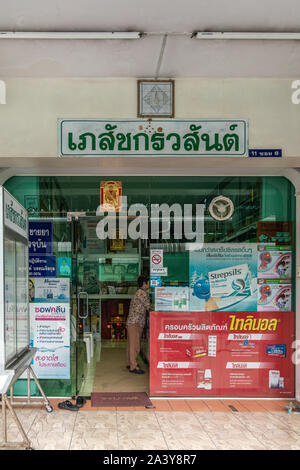 Chon Buri, Tailandia - 16 Marzo 2019: una moderna facciata in vetro e di farmacia con il cliente al bancone e colorato la pubblicità per i farmaci sulla Strada di Sukhumvit Road Foto Stock