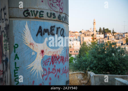 Disegno di una colomba bianca sulla barriera palestinese con vista di Betlemme, Palestina Foto Stock