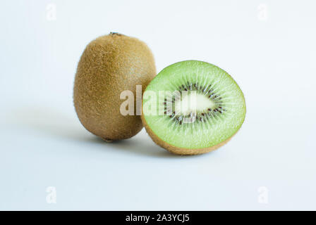 Tagliare e intere fresche Kiwi su sfondo bianco ina posizione verticale Foto Stock