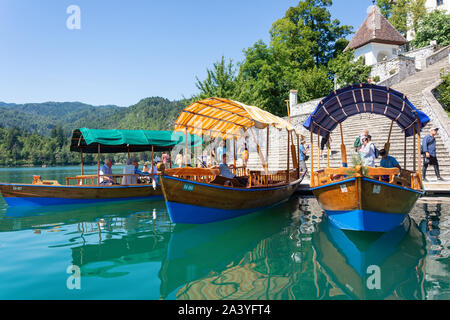 In legno tradizionali Pletna barche ormeggiate sulla isola di Bled, lago di Bled Bled, Alta Carniola Regione, Slovenia Foto Stock