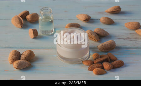 In casa olio di mandorle crema per il viso di una luce sullo sfondo di legno Foto Stock