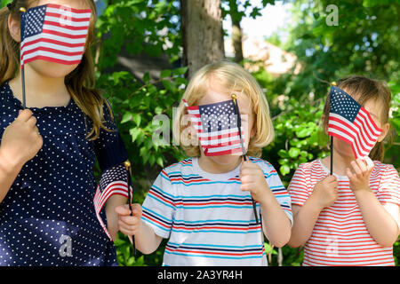 I bambini tenendo bandierine americane le loro facce Foto Stock