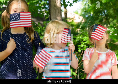 I bambini tenendo bandierine americane le loro facce Foto Stock