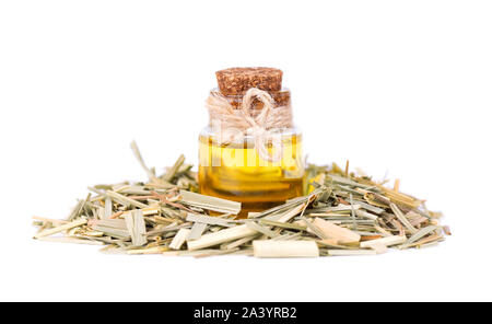 La citronella Olio essenziale in una bottiglia di vetro, isolata su uno sfondo bianco. Rametti secchi naturali di citronella. Foto Stock