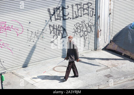 Los Angeles, California, USA. 5 Ottobre, 2019. Skid Row è un'area di circa 50 blocchi quadrati che si trova a est del centro cittadino di Los Angeles. Noto anche come Central City East e la zona ha una lunga storia come un quartiere residenziale per quelli con meno. Il non vedente è a piedi skid row. Credito: Katrina Kochneva/ZUMA filo/Alamy Live News Foto Stock