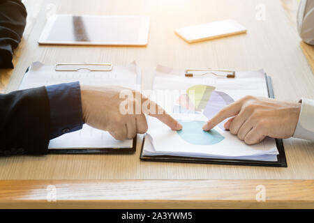 La gente di affari di gruppo il lavoro di squadra durante la relazione sulla conferenza per discutere lo schema finanziario, grafici sulla tavola in cafe. La gente di affari riunione seduti al caf Foto Stock