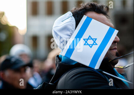 Colonia, Germania. 10 ottobre, 2019. Un uomo che indossa una kippa contiene un flag di ebrei durante un rallyAfter due persone sono state uccise da un bandito che tenti di entrare in una sinagoga a est della città tedesca di Halle è stato un rally programmati in Colonia. Centinaia di persone si sono radunate intorno alla cattedrale di Colonia per mostrare il loro supporto in solidarietà con la comunità degli ebrei in Halle e ovunque. Il rally è stato organizzato dalla Germania due partiti politici e Deutsch-Israelische Gesellschaft (DIG), un gruppo di lavoro dell'Associazione federale delle società German-Israeli. Credito: SOPA Immagini limitata/Alamy Live News Foto Stock