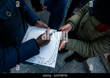 Un uomo scrive il suo nome in una tela a sostegno delle vittime durante il mese di marzo.Dopo due persone sono state uccise da un bandito che tenti di entrare in una sinagoga a est della città tedesca di Halle è stato un rally programmati in Colonia. Centinaia di persone si sono radunate intorno alla cattedrale di Colonia per mostrare il loro supporto in solidarietà con la comunità degli ebrei in Halle e ovunque. Il rally è stato organizzato dalla Germania due partiti politici e Deutsch-Israelische Gesellschaft (DIG), un gruppo di lavoro dell'Associazione federale delle società German-Israeli. Foto Stock