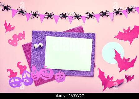 Creative Halloween piatto sfondo laici in rosa e viola con copy-spazio. Scheda vuota e decorazioni di carta: mazze, e jack lanterna zucche. Composizioni Foto Stock