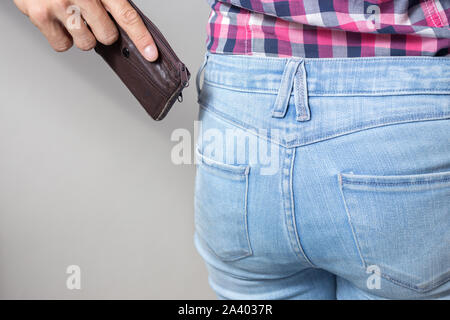 Pickpocketer la mano tirando rubare portafogli al di fuori della tasca posteriore, chiudere fino Foto Stock