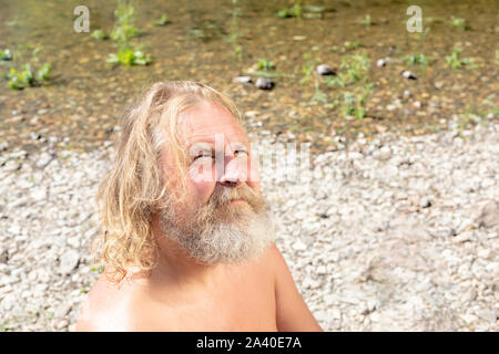 Il concetto di auto-conoscenza, la comunicazione con Dio, la ricerca per te. uomo anziano con un pensieroso vista sulla riva Foto Stock