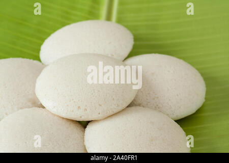 Fresh Indian folle - freschi cotti al vapore folli indiano (Idli / Torta di riso) disposte in modo decorativo su tradizionale foglia di banano. Luce naturale utilizzata. Foto Stock