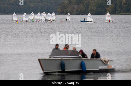 Berlino, Germania. 09oct, 2019. Numerose derive della barca di classe Optimist vela sul lago Wannsee, mentre in primo piano un piccolo motoscafo passa da. Credito: Monika Skolimowska/dpa-Zentralbild/ZB/dpa/Alamy Live News Foto Stock