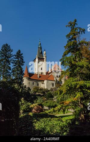 Pruhonice, Repubblica Ceca - 7 Ottobre 2019: vista panoramica del famoso castello romantico sul lago con la sua riflessione in acqua, in piedi su una collina. Foto Stock