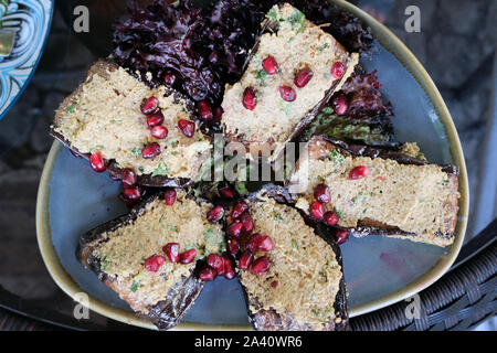 Il celebre piatto georgiano è melanzane fritte con noci e formaggio cosparso con grani di melograno sulla parte superiore. Deliziosi piatti a base di melanzane. Foto Stock