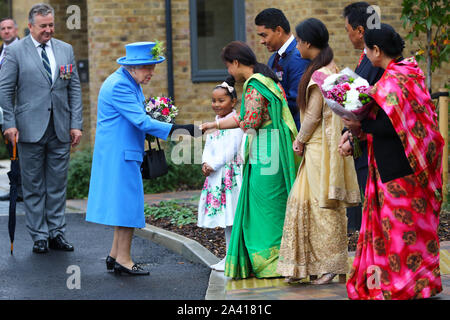 Queen Elizabeth II saluta i membri del pubblico come lei arriva a visitare Haig alloggiamento fiducia, Morden, Londra, dove lei si aprirà ufficialmente il loro nuovo sviluppo di alloggiamento per le forze armate di veterani e l'ex-community del servizio. Foto Stock