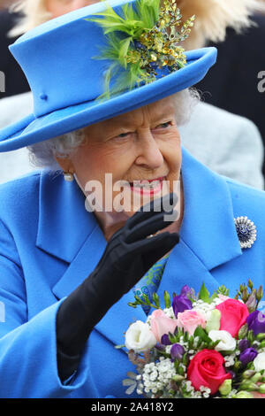 Queen Elizabeth II saluta i membri del pubblico come lei arriva a visitare Haig alloggiamento fiducia, Morden, Londra, dove lei si aprirà ufficialmente il loro nuovo sviluppo di alloggiamento per le forze armate di veterani e l'ex-community del servizio. Foto Stock