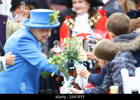 Queen Elizabeth II saluta i membri del pubblico come lei arriva a visitare Haig alloggiamento fiducia, Morden, Londra, dove lei si aprirà ufficialmente il loro nuovo sviluppo di alloggiamento per le forze armate di veterani e l'ex-community del servizio. Foto Stock