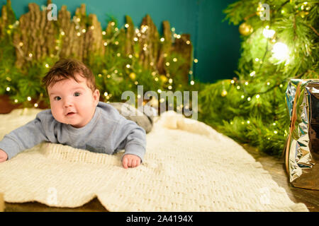 Un bambino vicino a un albero di Natale. Little Boy festeggiano il Natale. del bambino prima di natale. Foto Stock