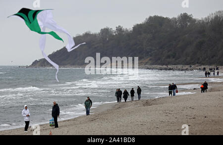 Rerik, Germania. Undicesimo oct, 2019. Gli scuotipaglia sono in movimento con il vento e le onde a mar Baltico, un aquilone vola in aria. Credito: Bernd Wüstneck/dpa-Zentralbild/dpa/Alamy Live News Foto Stock