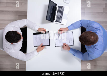 Una vista in elevazione dei due proprietari seduta faccia a faccia a discutere il nuovo progetto Foto Stock