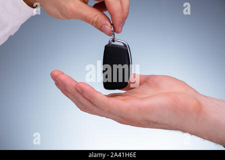 Close-up di un venditore auto di consegnare la nuova chiave auto al proprietario del canto Foto Stock