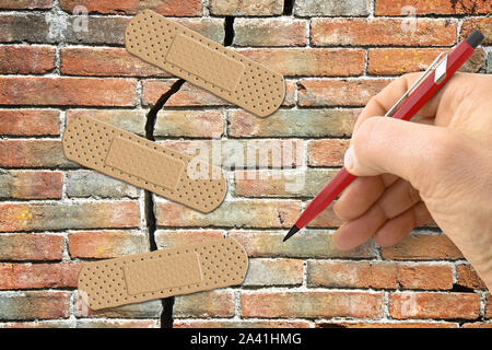 Ristrutturazione di un antico muro di mattoni - Concetto di immagine con la scrittura a mano e bendaggio adesivo Foto Stock