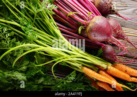 Organico fresco barbabietole e carote da cucina in legno tavolo rustico vista ravvicinata Foto Stock
