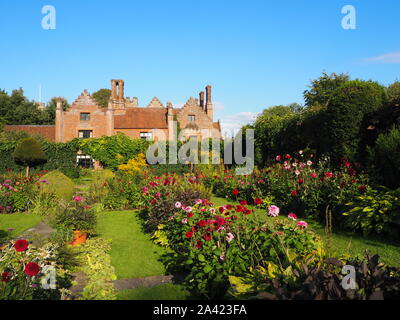 Chenies Manor House su una tarda serata estiva, Sunken garden dalie, percorsi di erba e piante erbacee confine in bel tempo.. Foto Stock