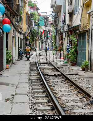 Moto nel villaggio ferroviario o treno Street, una stretta viuzza con linea ferroviaria vicino a vecchie case, Hanoi, Vietnam Asia Foto Stock