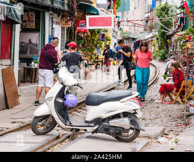 I turisti in caffè nel villaggio ferroviario o treno Street, strette corsie con linea ferroviaria, Hanoi, Vietnam Asia Foto Stock