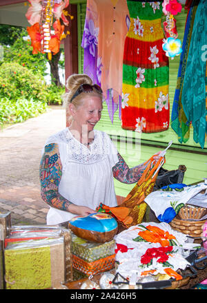 donna di mezza età shopping al mercato locale nelle Seychelles, guardando i bei tessuti multicolore al piccolo Stand, Victoria, Seychelles, Foto Stock