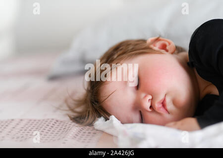 Bambino sonno diurno. Un sano sonno diurno per il neonato. Il bambino dorme in un ortopedico di bambini cocoon sul letto. bambino dopo riposo attivo Foto Stock