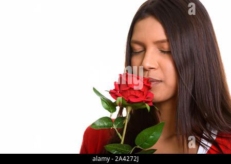 Studio shot del giovane bella donna brasiliana odore di rose rosse Foto Stock