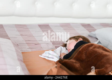 Bambino sonno diurno. Un sano sonno diurno per il neonato. Il bambino dorme in un ortopedico di bambini cocoon sul letto. bambino dopo riposo attivo Foto Stock