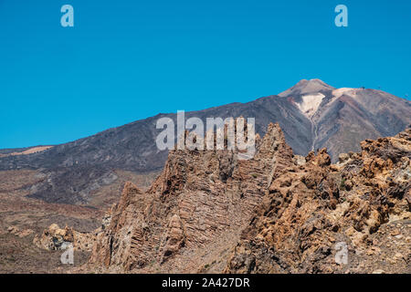 Il Teide e strati di roccia vulcanica nel paesaggio del deserto e cielo blu - Foto Stock