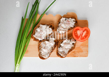 Colazione ucraino. Pancetta Affumicata. La pancetta e il pane su una vecchia scheda. con le cipolle e i pomodori. Foto Stock