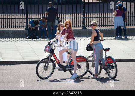 Londra, Inghilterra, Regno Unito. Le giovani donne a Santander noleggio cicli di fronte a Buckingham Palace Foto Stock