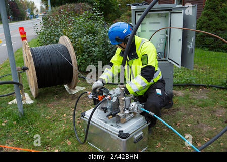 L'uomo installazione in fibra ottica di connessione a internet in una zona residenziale Foto Stock