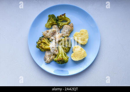 Cavolfiore con pezzi di carne. a forma di cuore di patate. su una piastra di blu. Pesce alla griglia. Pesce salmone bistecca con verdi, broccoli, cavolfiori Foto Stock
