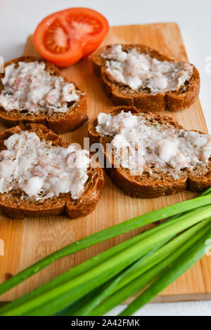 Colazione ucraino. Pancetta Affumicata. La pancetta e il pane su una vecchia scheda. con le cipolle e i pomodori. Foto Stock