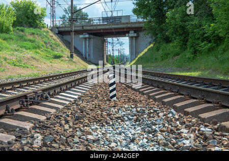 Elettrificate della linea ferroviaria che attraversa il ponte stradale e attraverso il deviatoio ferroviario andando a ponte ferroviario sul fiume Foto Stock