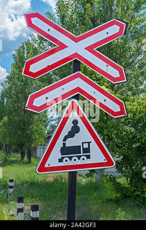 Avvertenza cartello stradale in prossimità di un incrocio ferroviario senza una barriera Foto Stock