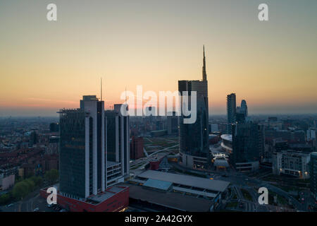 Antenna vista notturna di Milano prima di sunrise. Volando sopra la costruzione e il boulevard. Foto Stock