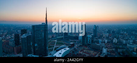 Antenna vista notturna di Milano prima di sunrise. Volando sopra la costruzione e il boulevard. Foto Stock