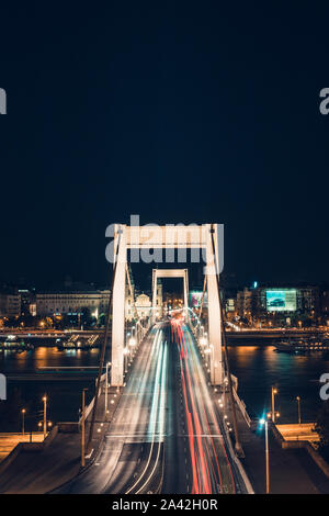 Di notte il traffico di tempo oltre il ponte Elisabetta. Si attraversa il fiume Danubio e la collega Buda e Pest insieme. Budapest, Ungheria. Foto Stock